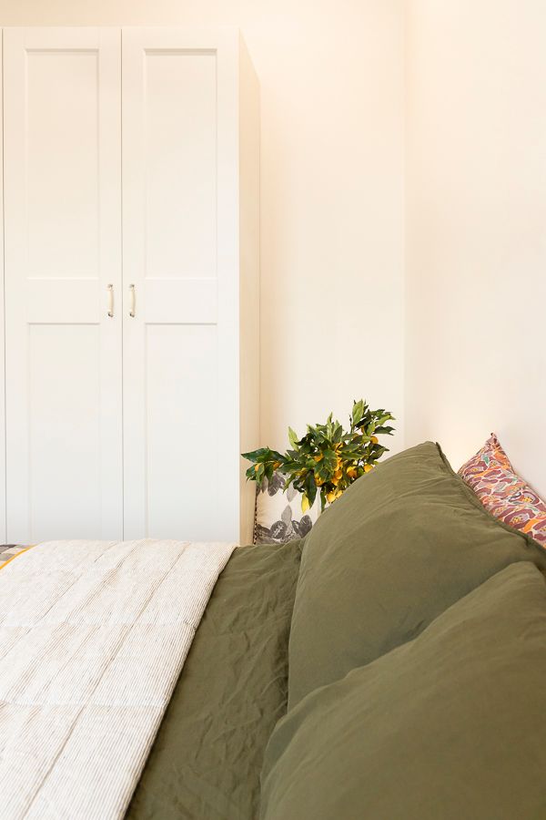 Interior property photo by Em Callaghan Photography of a bedroom interior with white walls and wardrobe, a queen bed with green linen.