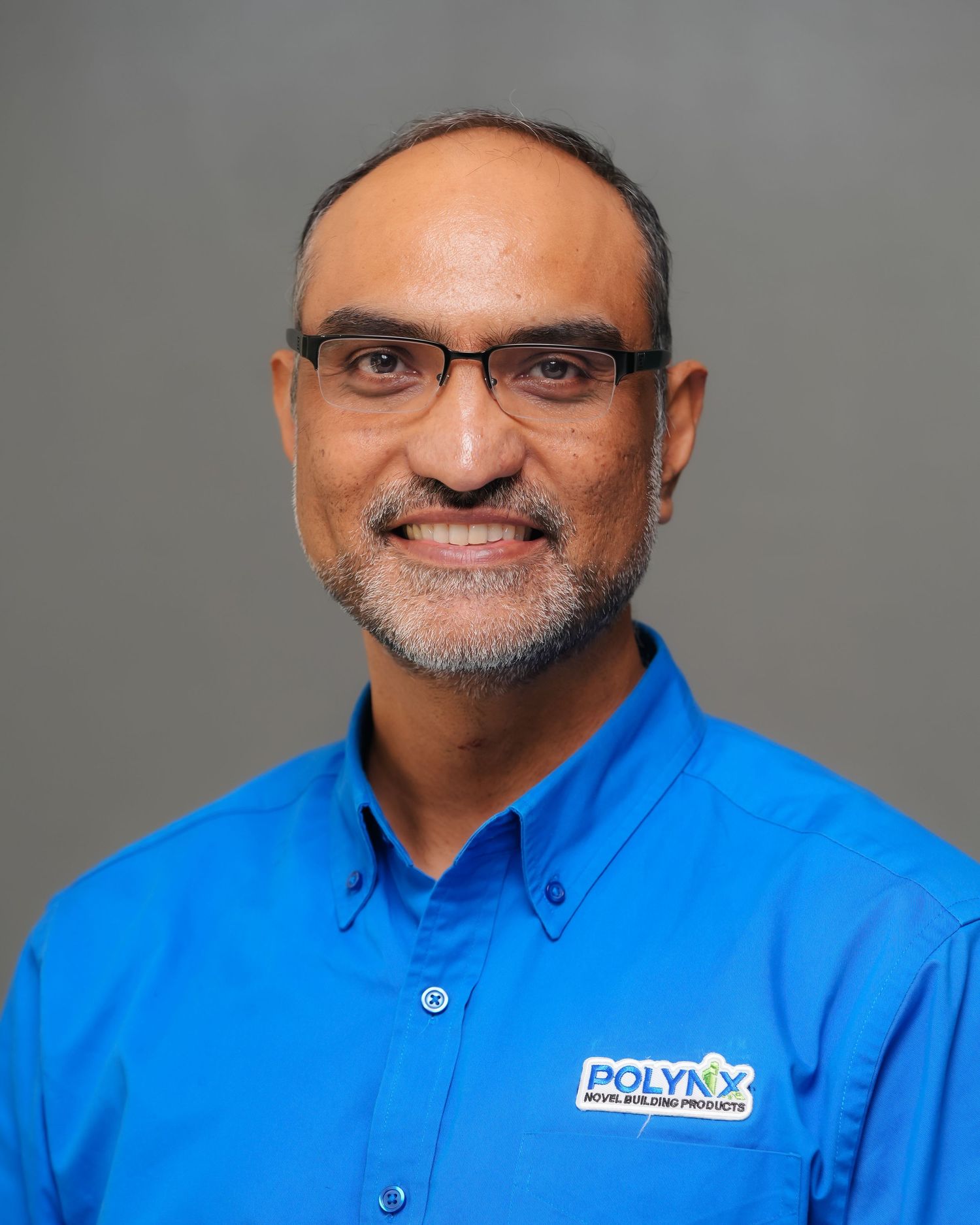 Man in blue Polynx Building Products polo shirt smiling, professional headshot photo.