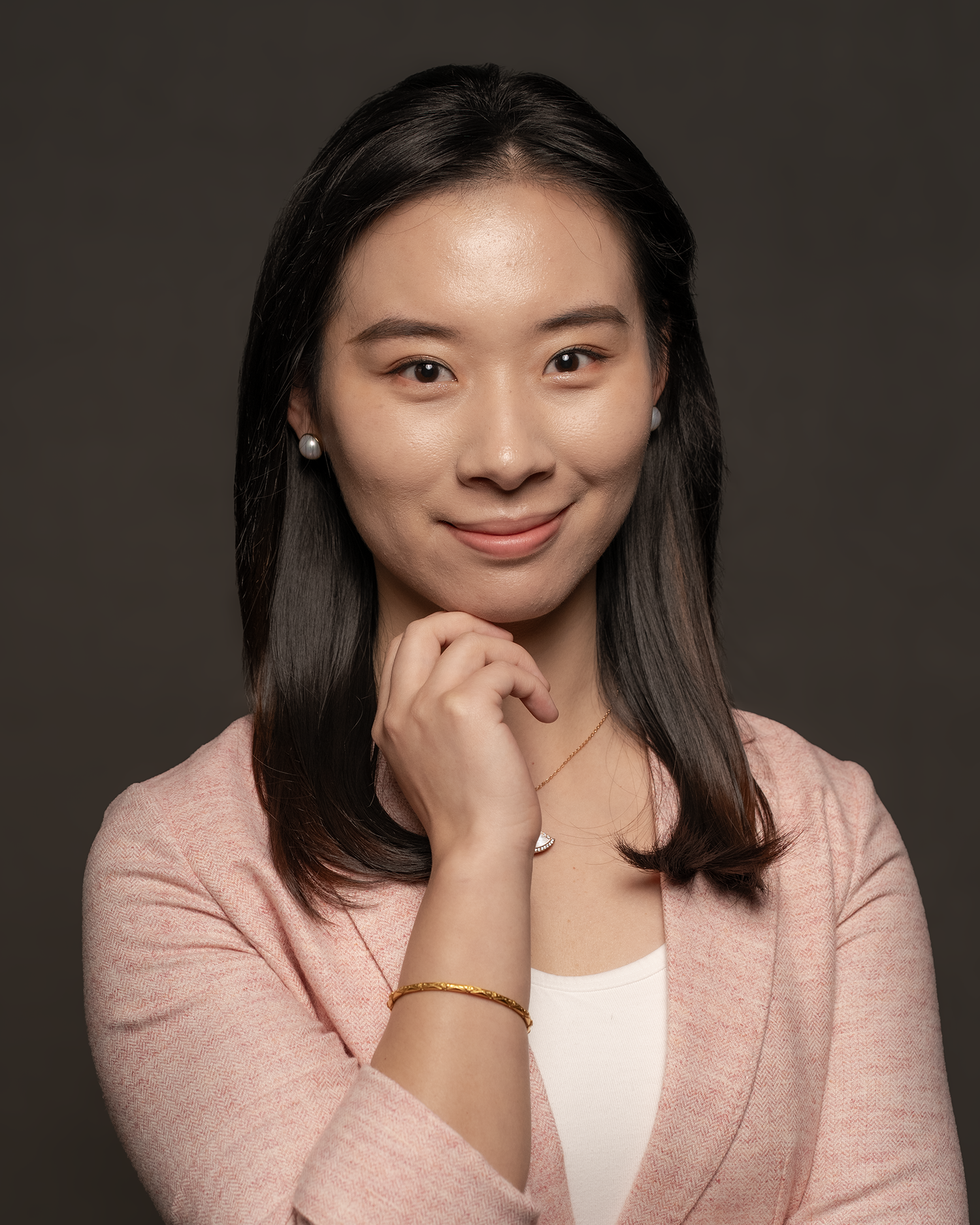 Professional headshot of confident woman in pink blazer