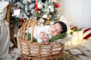 new born baby sleeping on wooden cradle - Jasmeet K Photography