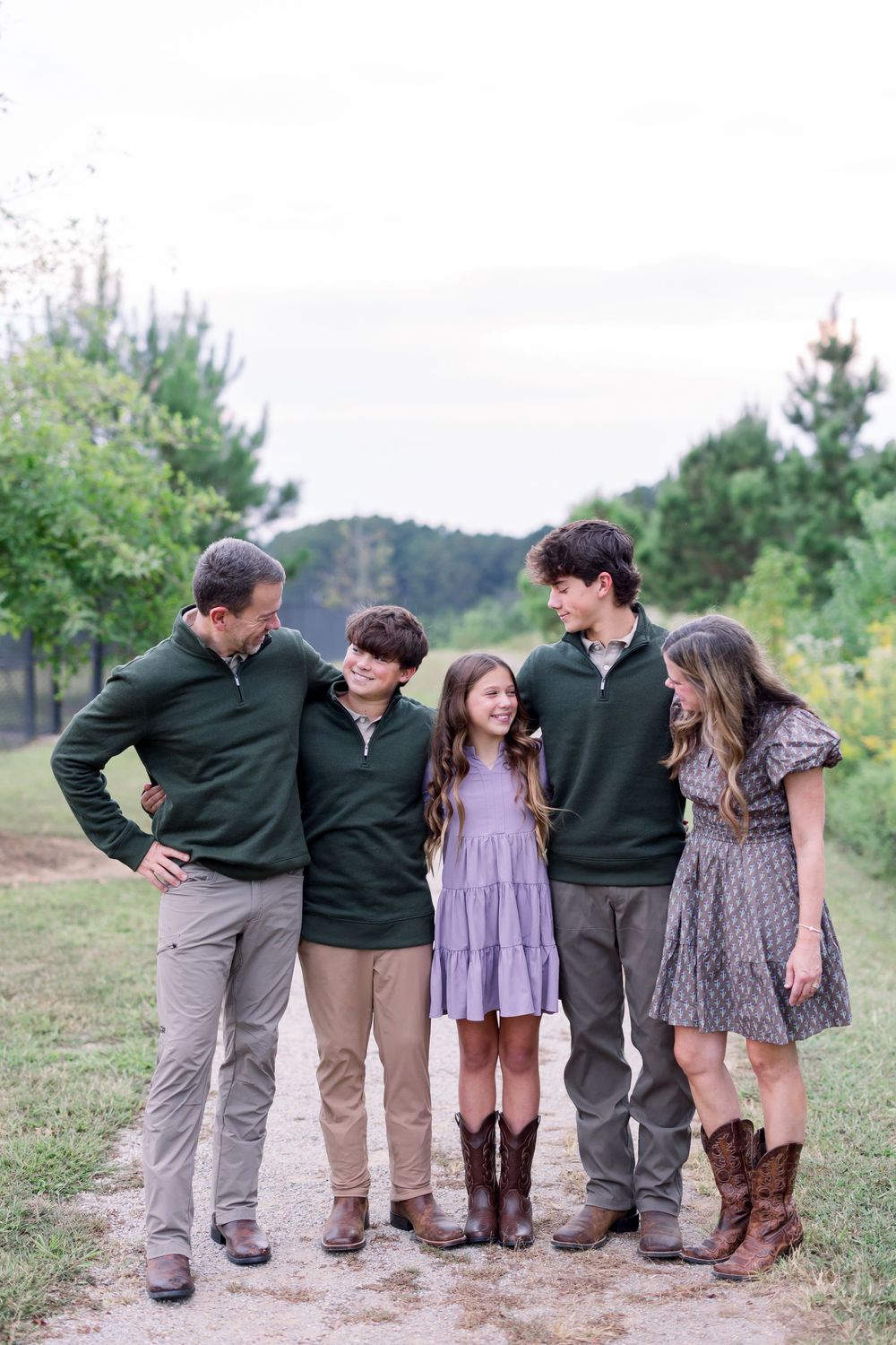 A group of five people in coordinated green and khaki outfits pose playfully together outdoors in a casual photo series.