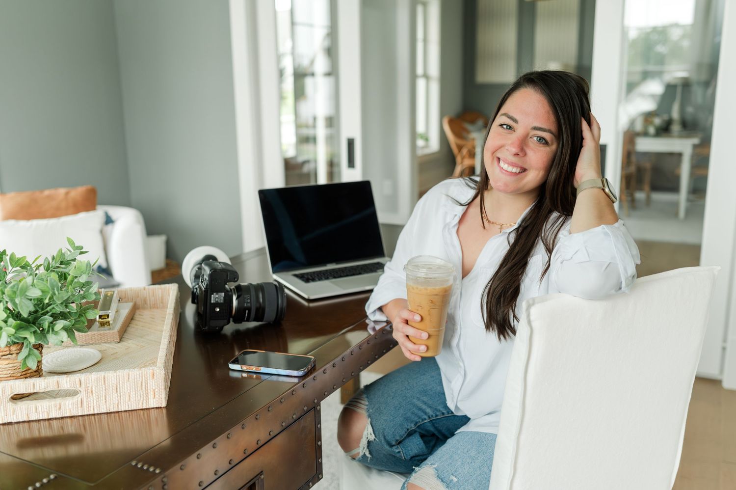 Woman working from home with laptop and coffee in bright modern space.