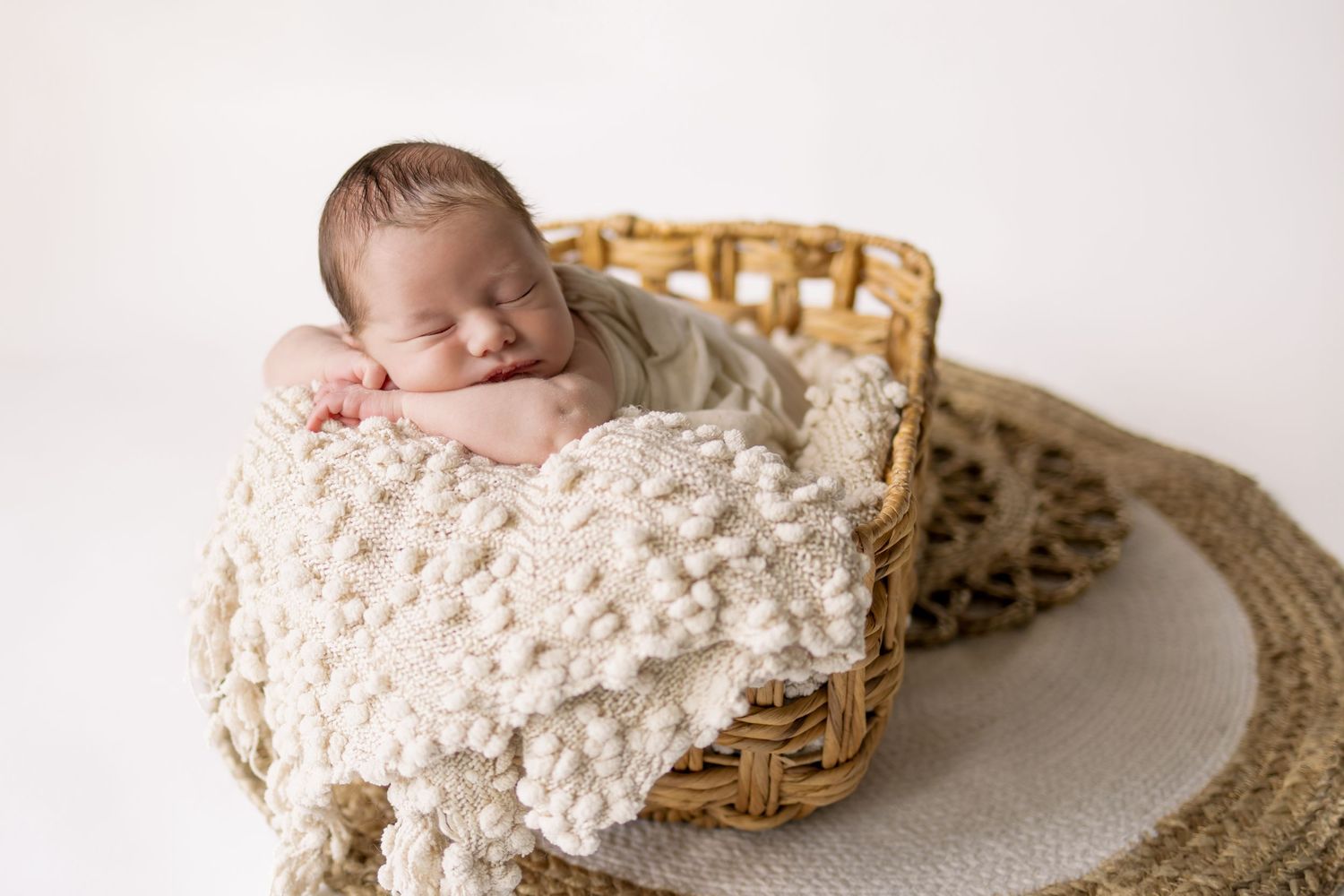 baby in basket head on hands