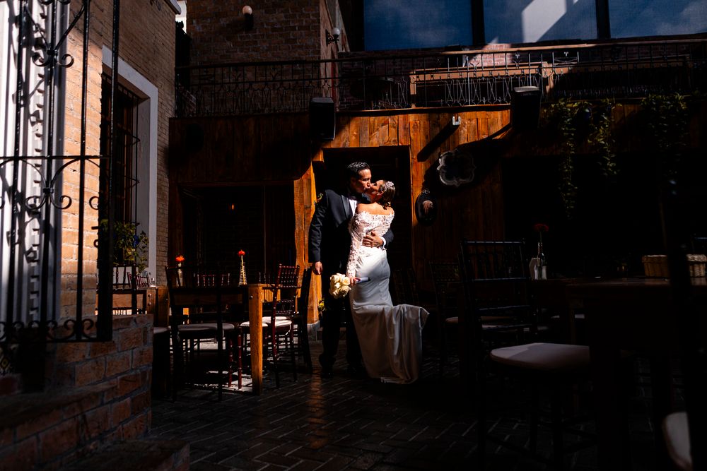 A dark and moody interior of an industrial-style restaurant with exposed brick walls and warm ambient lighting.