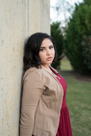 Fashion portraits combining tan cardigan and burgundy dress against outdoor setting.