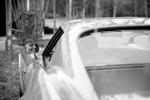 Partial view of a classic car's chrome details and bodywork.