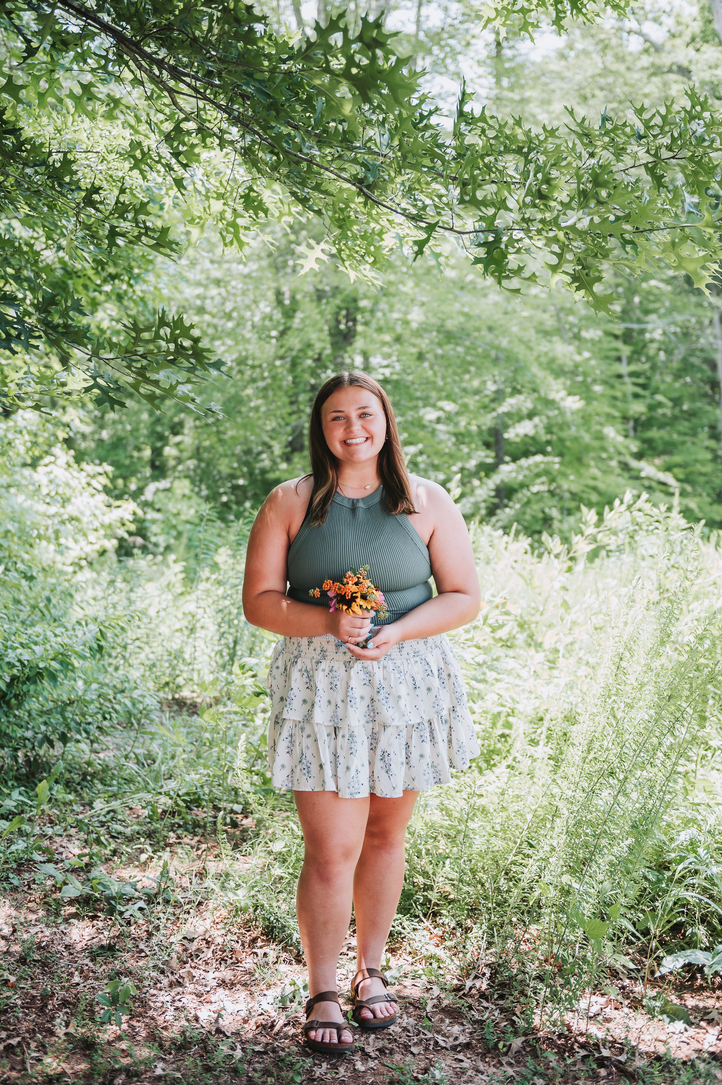 Casual outdoor photoshoot in a lush garden setting with natural lighting.