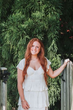 White picket fence and lush greenery create natural backdrop for outdoor photography.