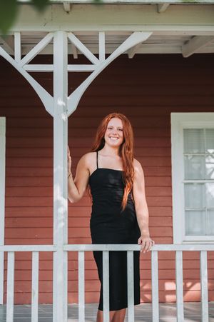 A red brick building with white porch posts creates charming rustic backdrop for photos.