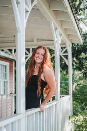 Summer portrait session on a white porch with natural light and architectural details.
