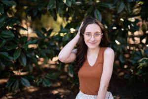 A sunny outdoor portrait among lush green magnolia leaves.