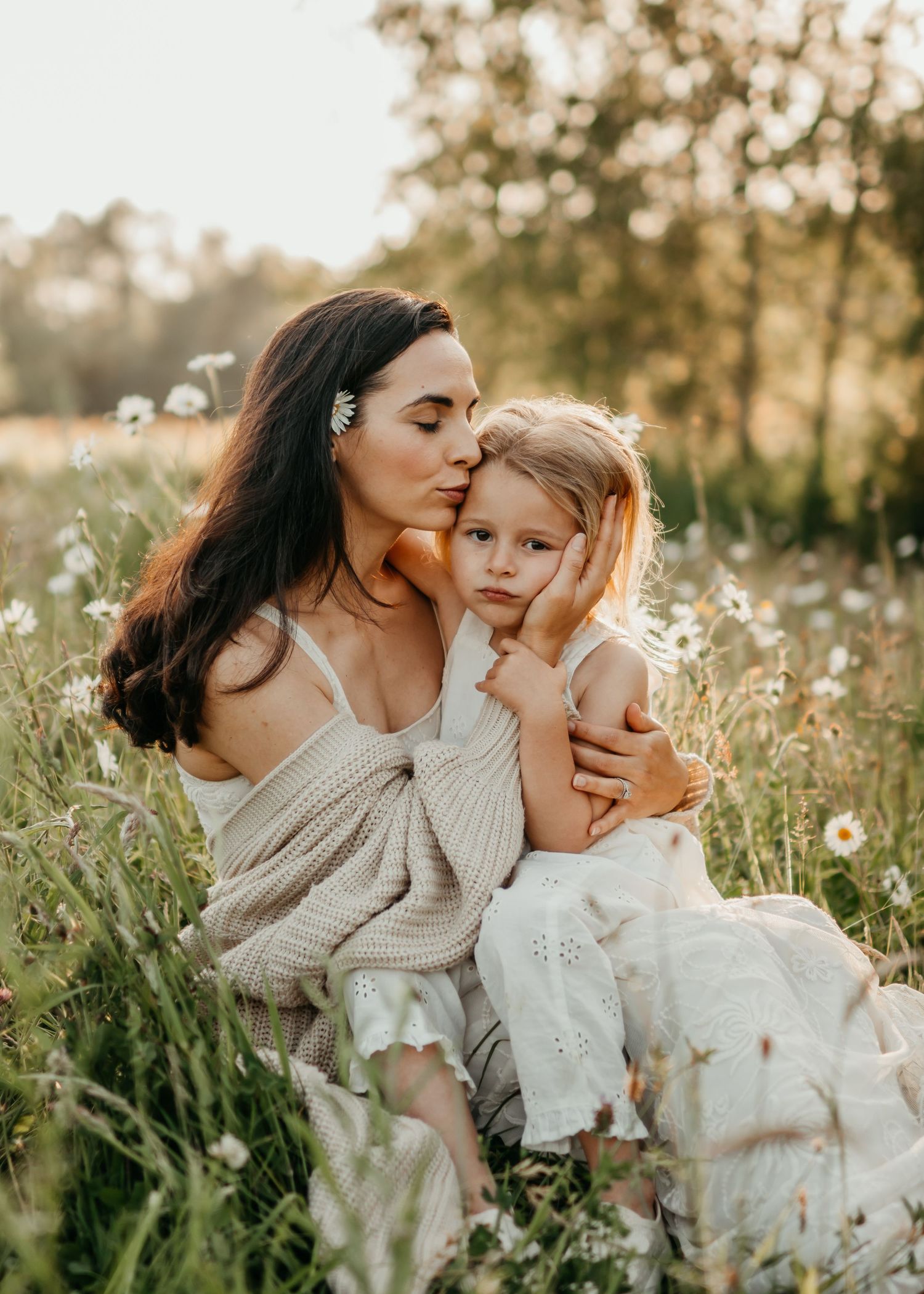 A mother gently kissing her daughter during her photo session with Forever Ours Photography in Leybourne Lakes, Kent, UK