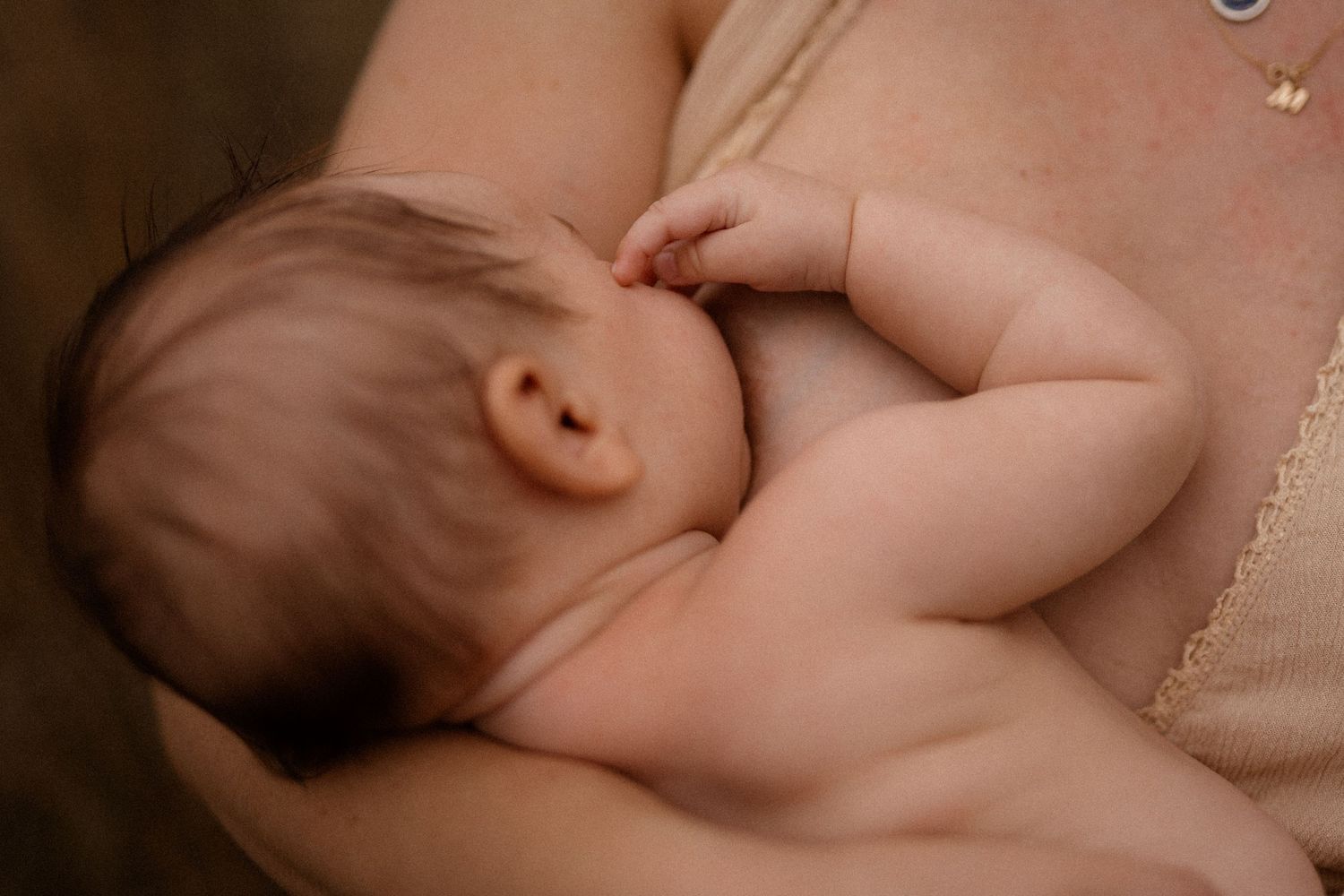 Nahaufnahme einer winzigen Babyhand, die den Finger eines Erwachsenen im zärtlichen Moment greift.