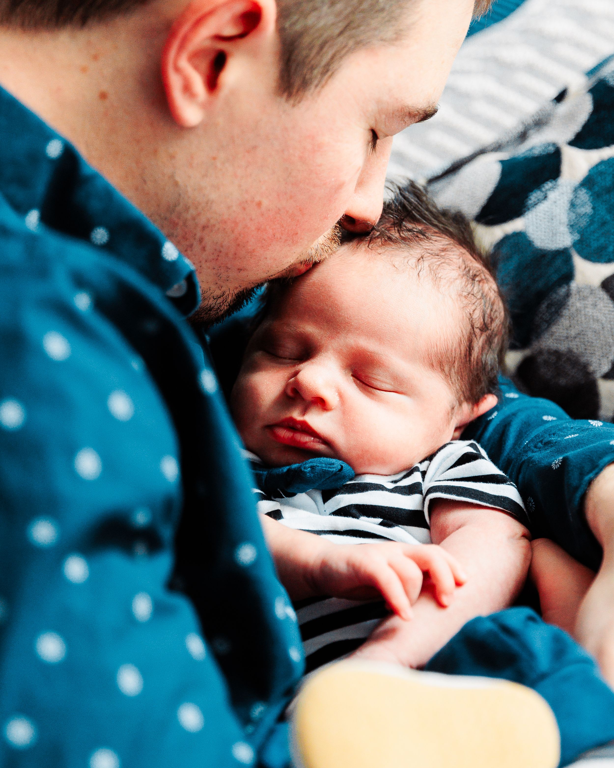 Dad kisses newborn son in his home in Attleboro
