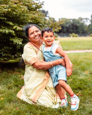 A grandmother hugs her grandson in a park.