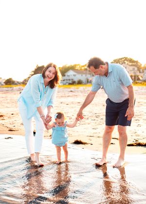 Grandparents walking with their one year old granddaughter through a tide pool at Goose Rocks Beach in Kennebunkport, ME