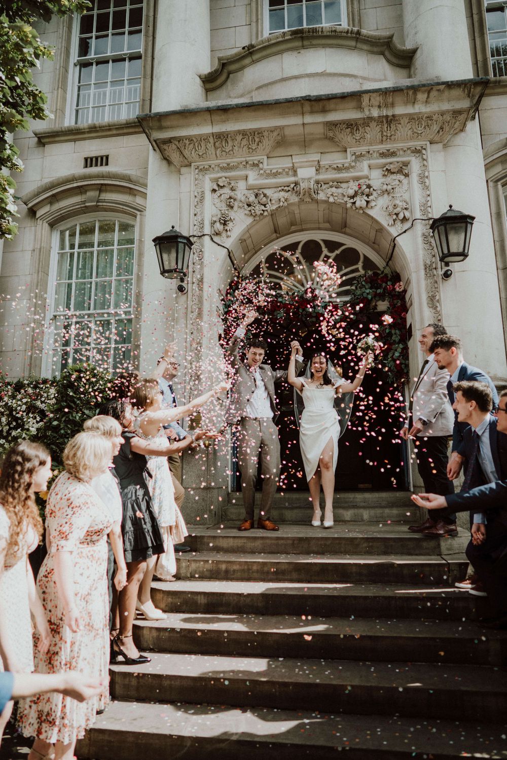 bride and groom confetti exit at chelsea old town hall, London wedding, captured in a documentary style
