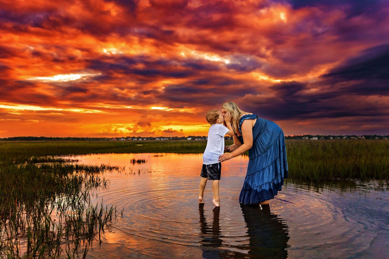 Two people embrace on rooftop against dramatic orange and purple sunset sky.