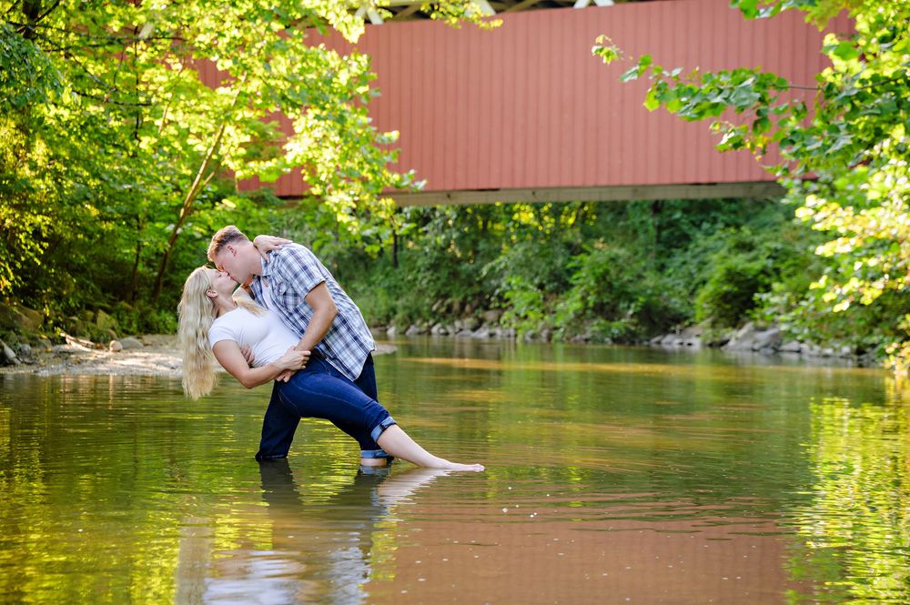 A fun summer engagement session in a river by Everett Covered Bridge in Cuyahoga Valley National Park by a wedding photographer in Ohio