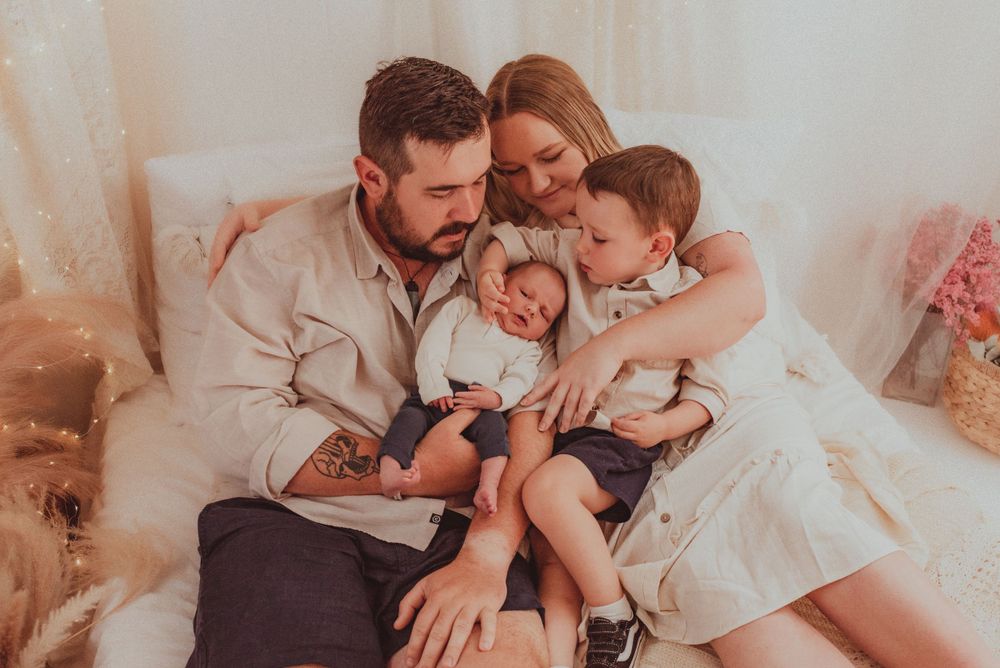 An intimate family moment captured in a bright, minimalist indoor setting.