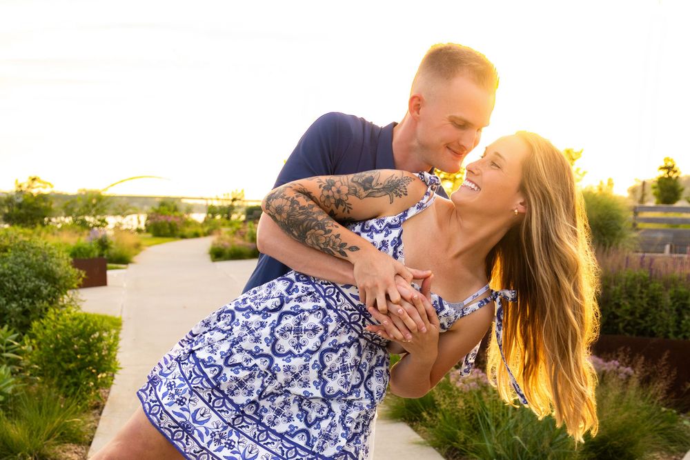 Warm, romantic engagement photo of a male dipping his fiancee with the golden hour sunset shinning in from behind them taken in Sioux City.