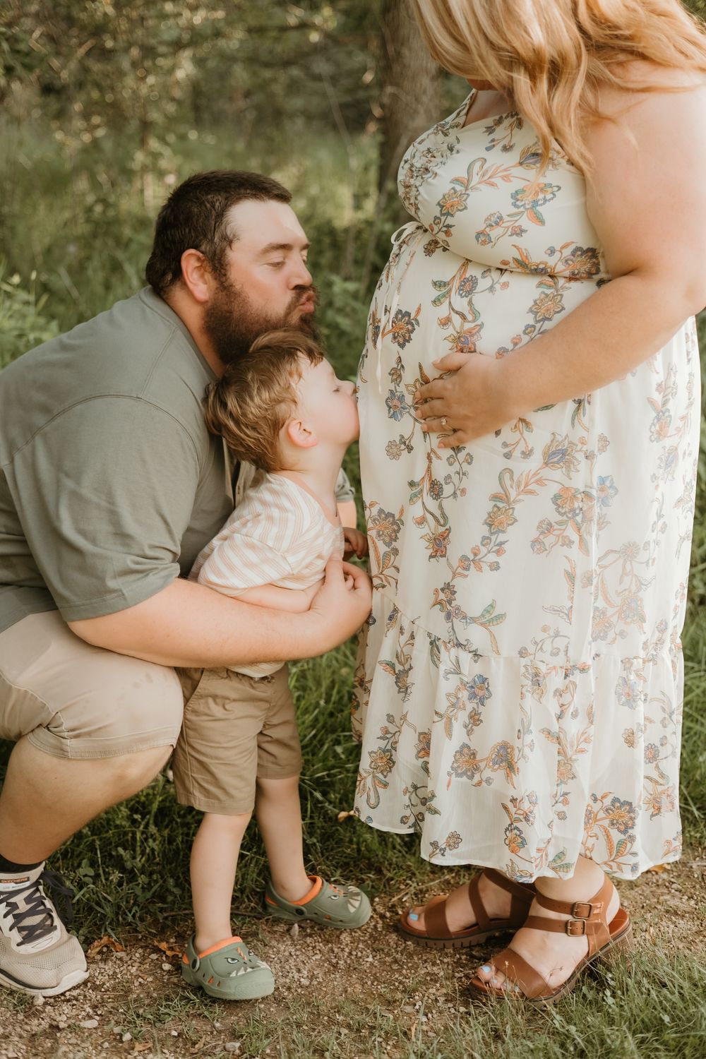 dad and son kissing belly maternity