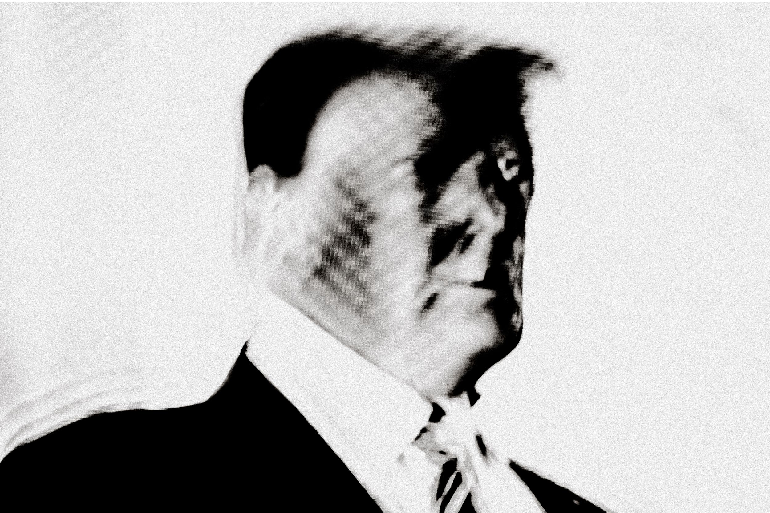 Black and white portrait of a man in a suit and tie, captured in dramatic side profile lighting.