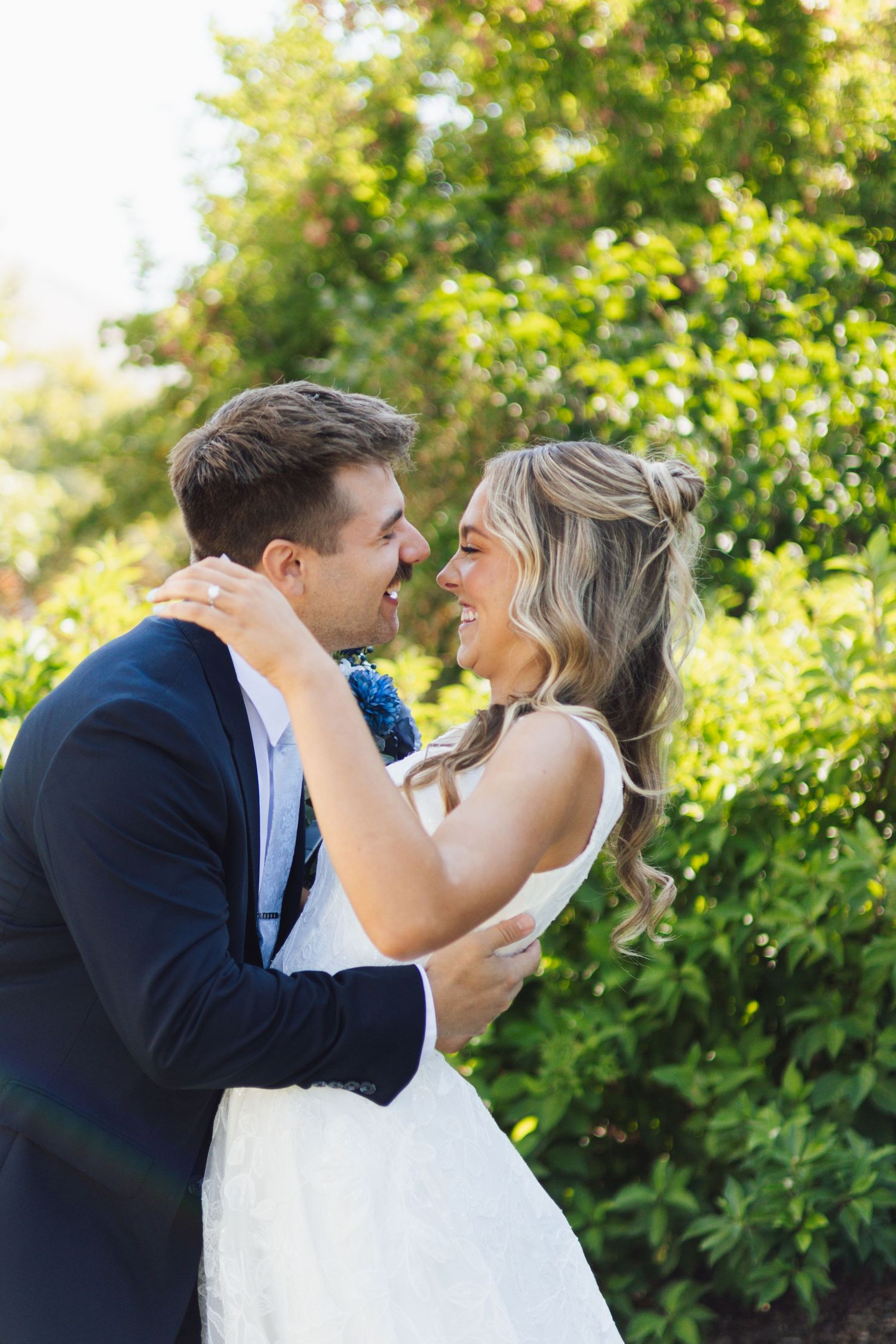 First look session with bride and groom with beautiful green backdrop in front of the Brigham City LDS temple in Brigham City, Utah