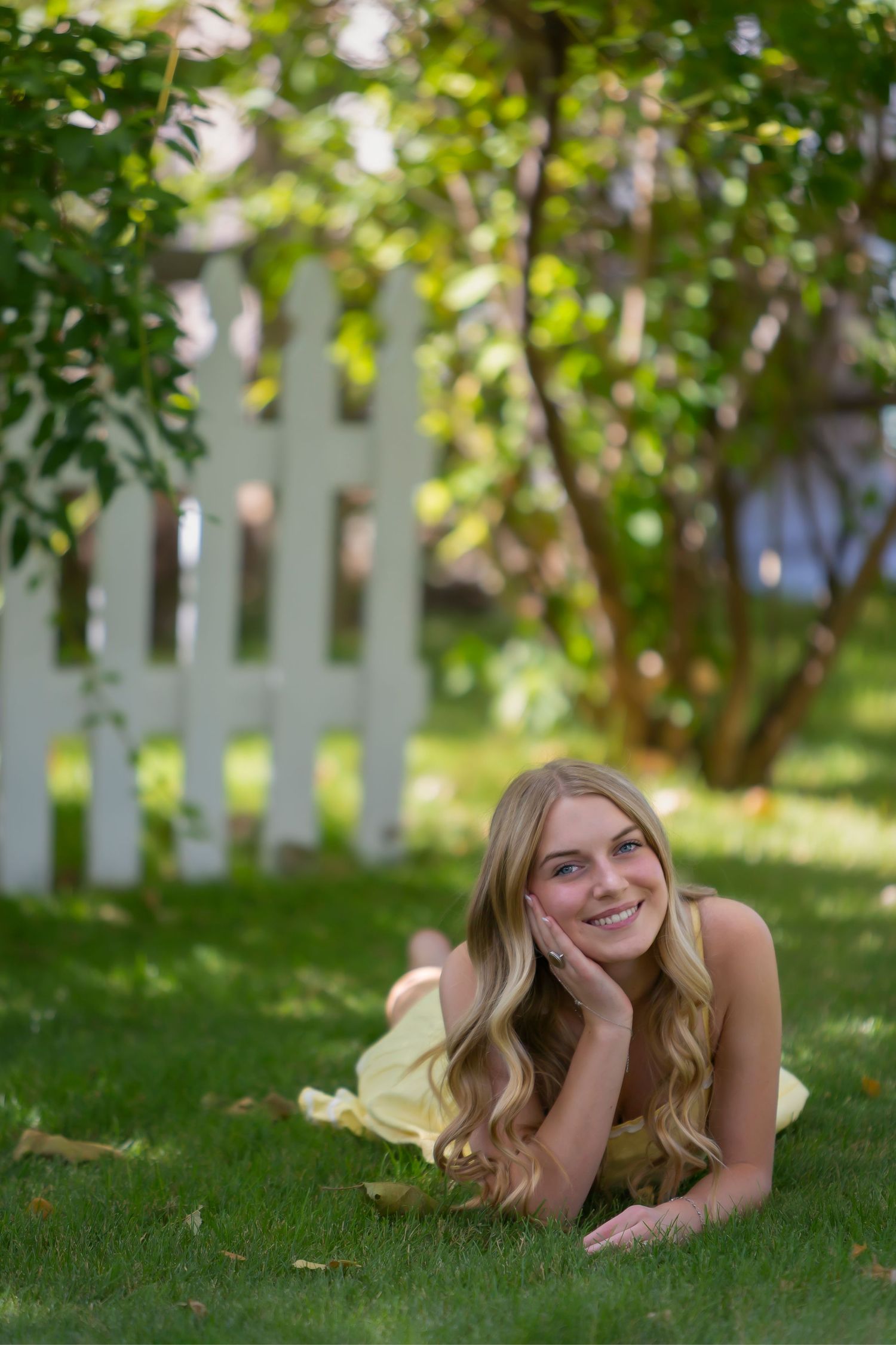 Senior girl laying in grass wearing yellow