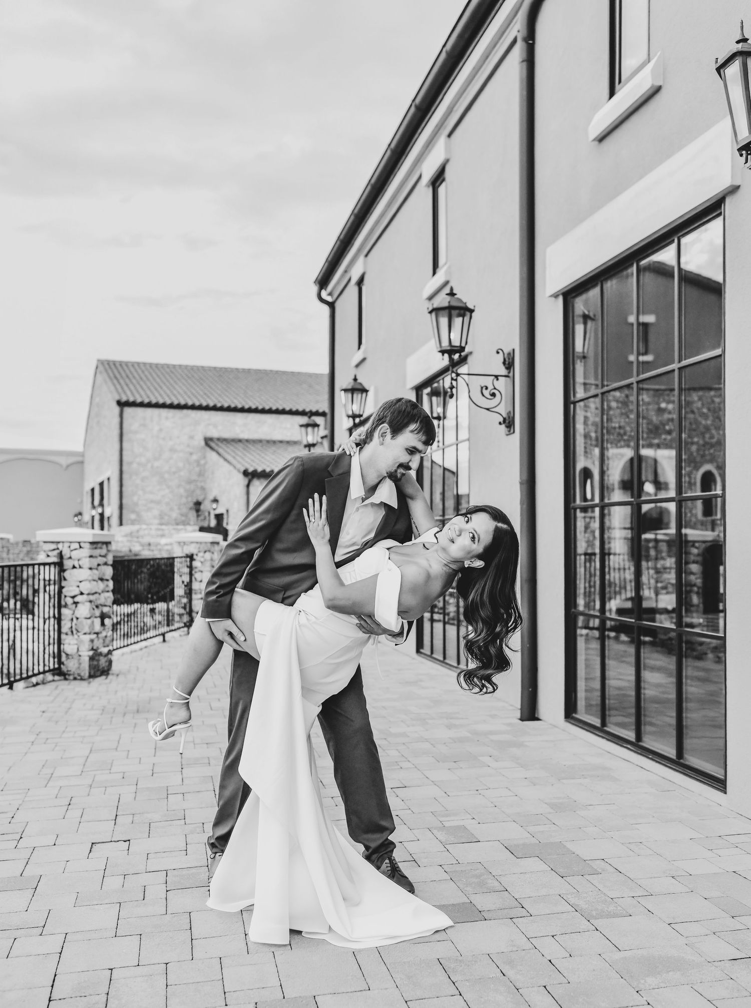 Romantic couple portrait framed by warm stone and Mediterranean-inspired architecture