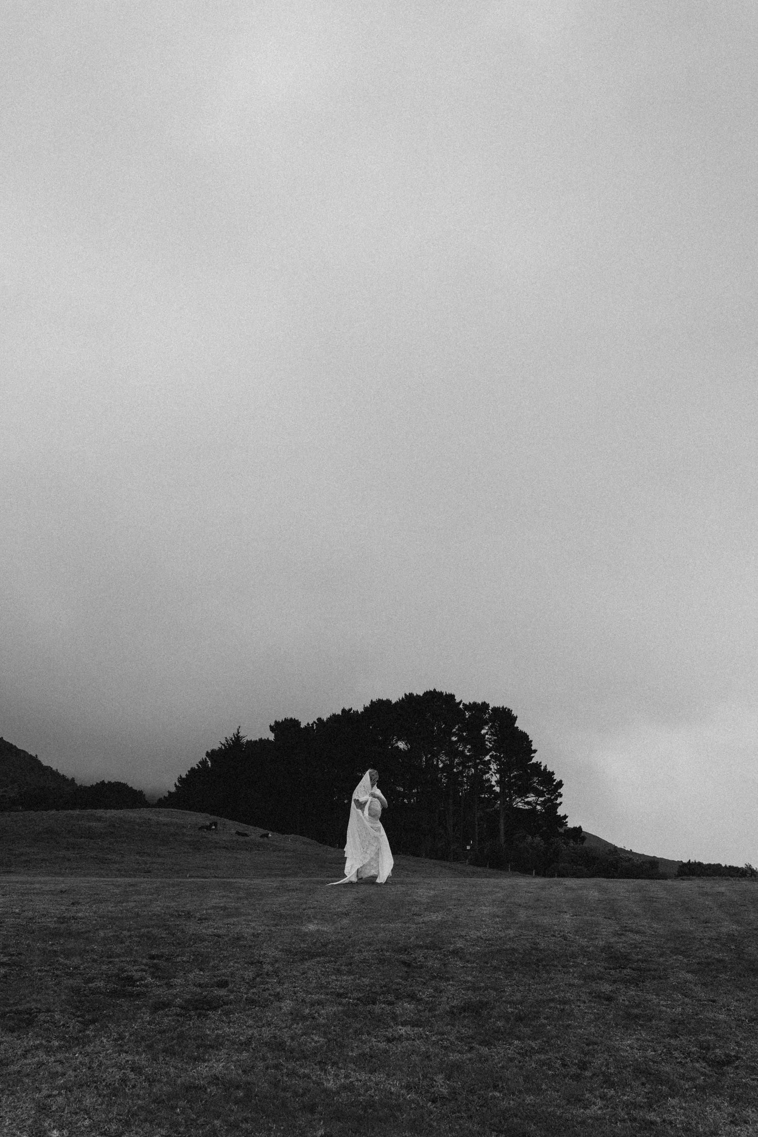 Black and white photo of a Pregnant woman during outdoor maternity photoshoot in Raglan, New Zealand
