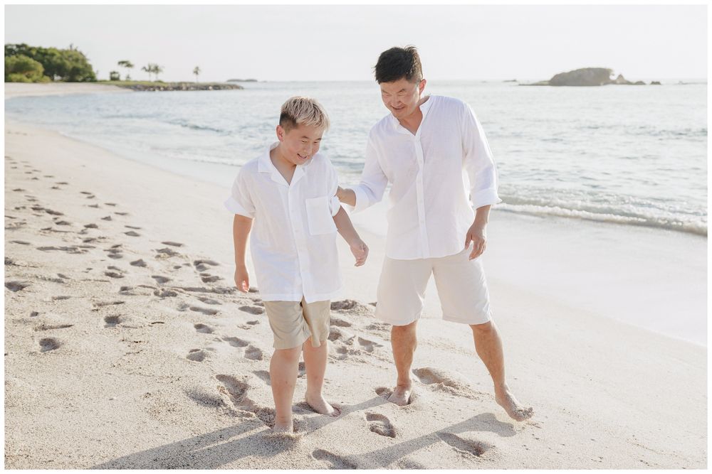 Punta Mita Family Photographer capturing a father and son walking and playing together along the calm ocean shore.