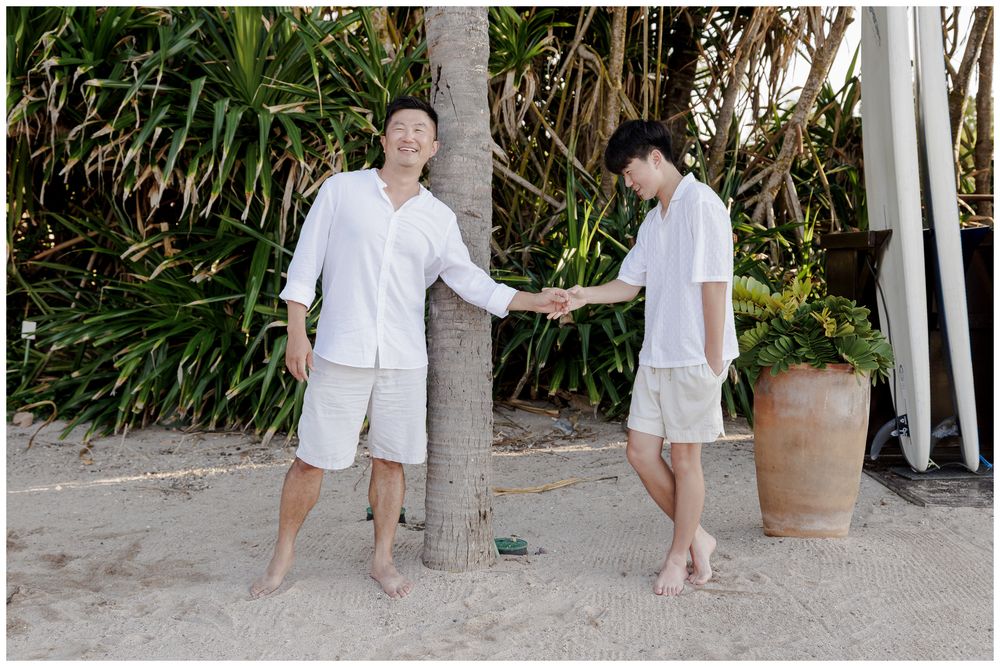 Punta Mita Family Photographer documenting a playful beach moment beneath a palm tree at The St. Regis Punta Mita.