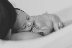 Intimate black and white close-up of a sleeping newborn.