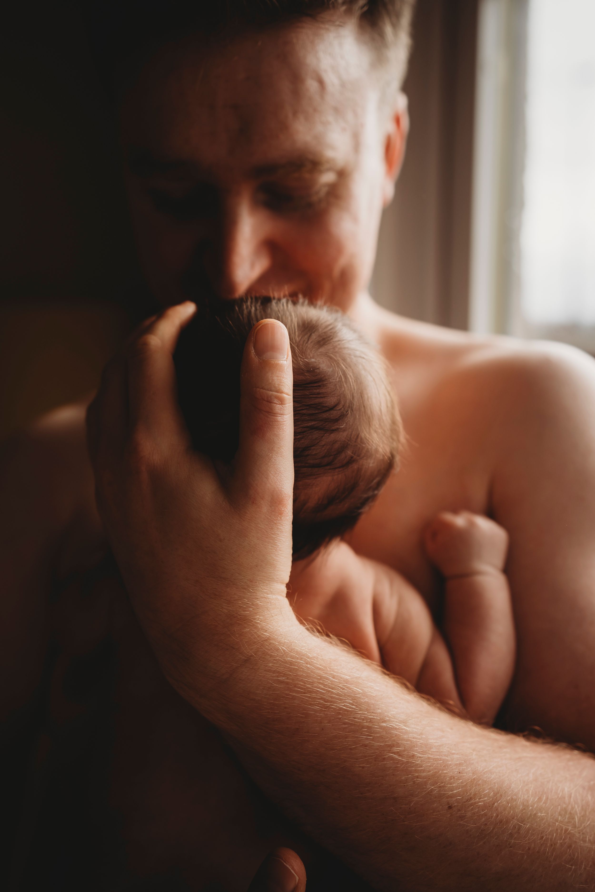 A close-up capture of gentle parental affection with a sleeping newborn.