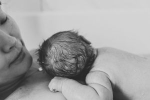 Black and white intimate photo capturing peaceful skin-to-skin bonding moment.