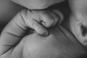 Close-up black and white photograph focusing on a baby's small hand.