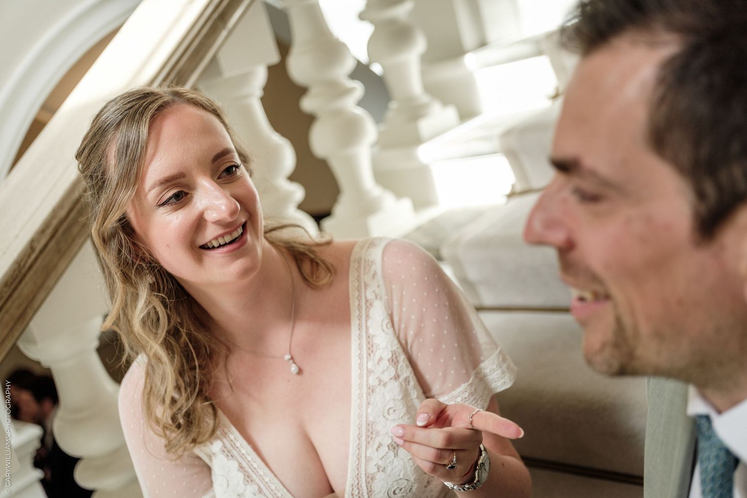 Bride and groom sharing a joyful moment on elegant staircase during wedding ceremony.