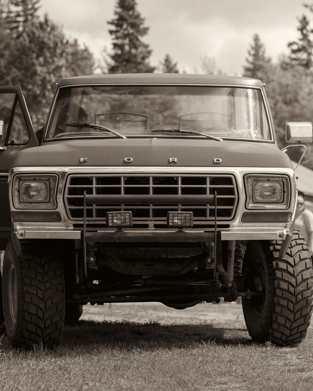 Vintage black and white photo of a classic Ford truck parked outdoors at a wedding venue.