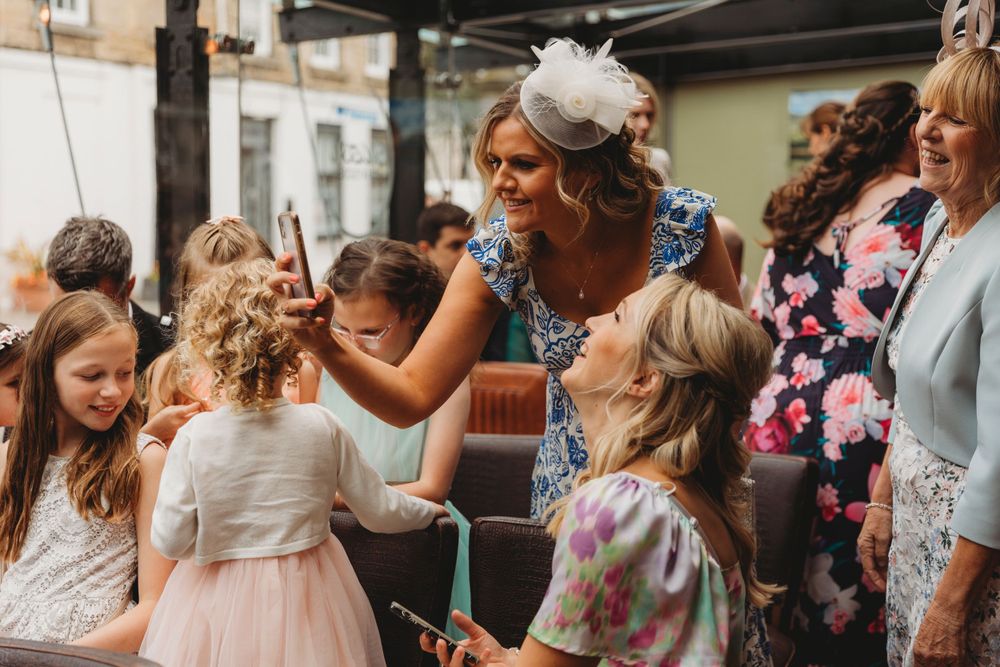 Wedding guests enjoying festivities with children in a casual outdoor setting.