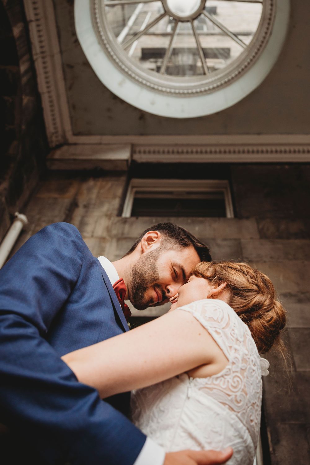 A tender embrace captured under an ornate circular skylight.
