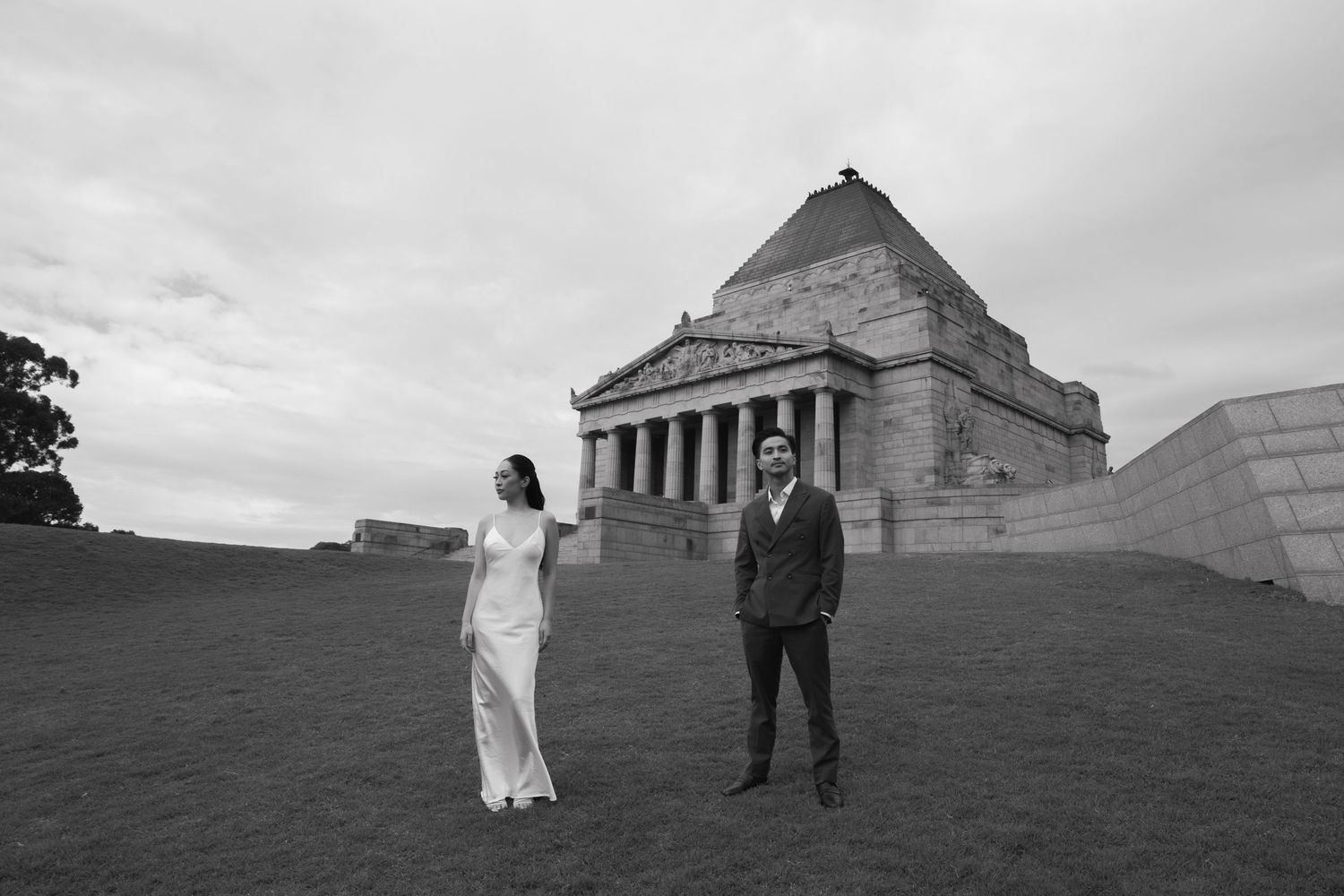 Grand neoclassical war memorial with tall columns and wide stone steps under an overcast sky in Melbourne, Australia.