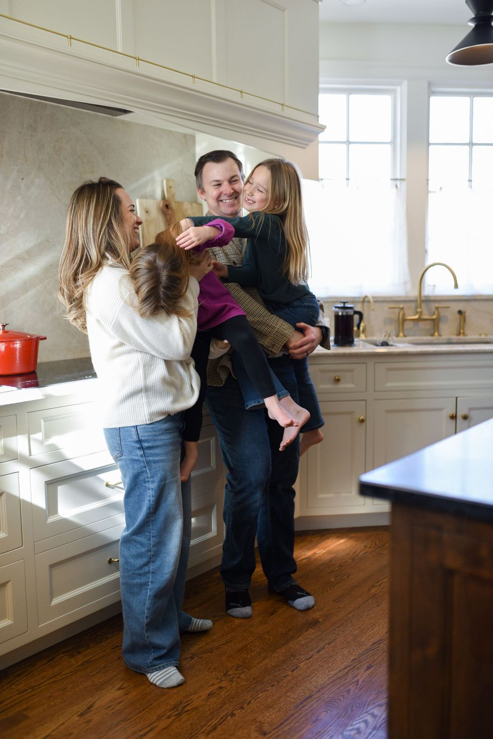 A family standing in the kitchen during an in-home lifestyle session.
