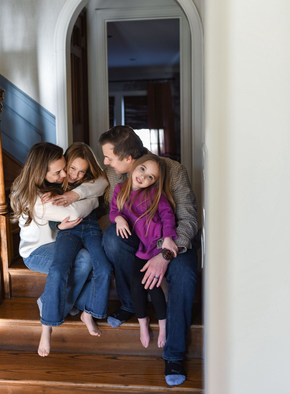 A family sitting on the stairs during an in-home lifestyle session.