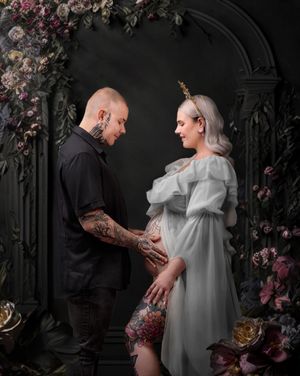 Sydney maternity photographer: parents-to-be, mum in a gray dress, holding hands against a romantic gothic black floral framed digital scene