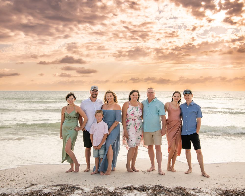 Extended family beach session during a Dunedin, FL vacation, featuring relatives gathered by the water at golden hour.