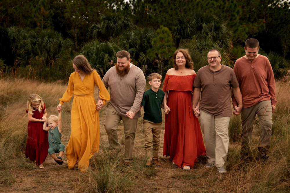 Outdoor family photography session in Clearwater, Florida, featuring candid connection among parents, children, and relatives.