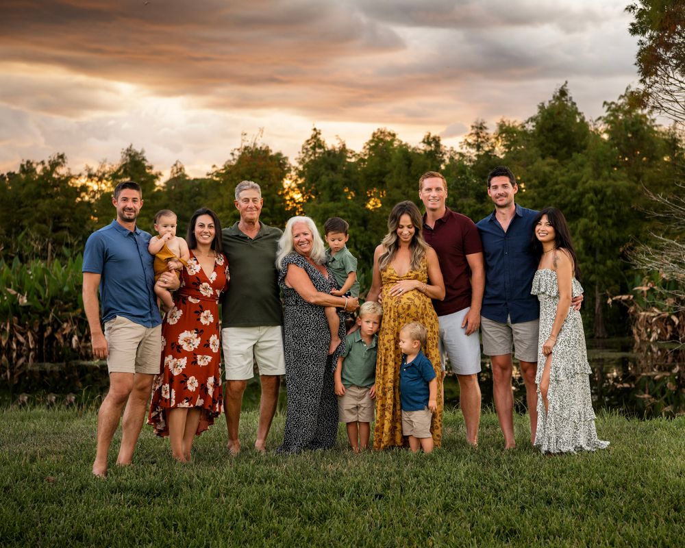 Large extended family gathered for a professional outdoor portrait session in Tampa, Florida at sunset.