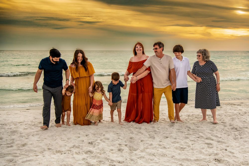 Extended family walking along Madeira Beach, Florida at sunset during a joyful multi-generational family session.