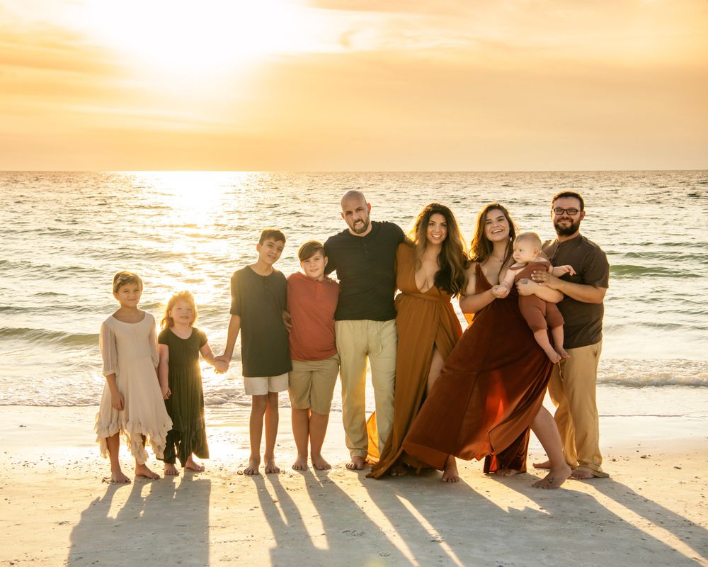 Two families enjoying a golden hour beach session in Dunedin, FL, featuring siblings, children, and authentic connection.